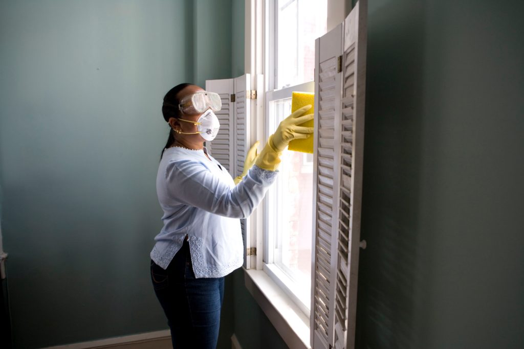 mulher limpezando janela franquia de higienização