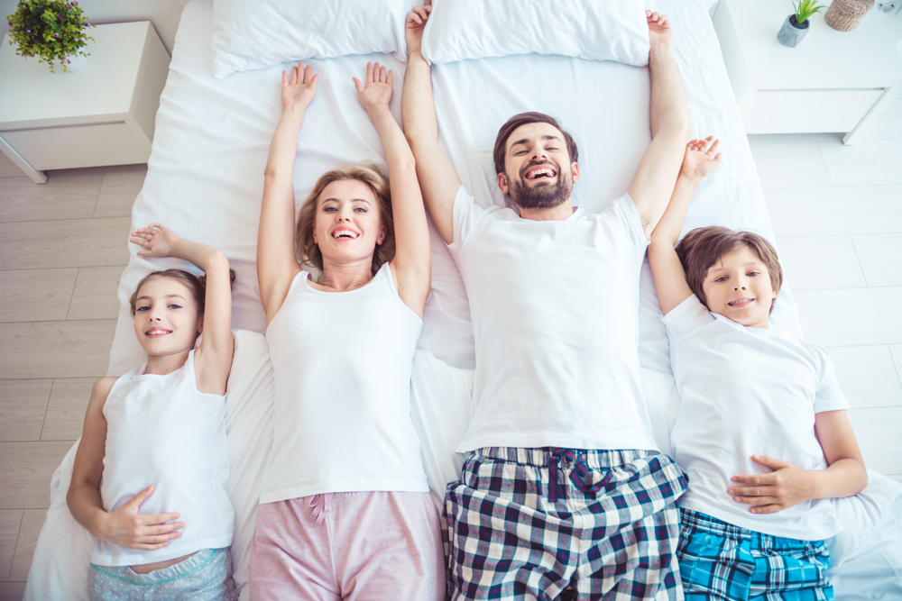 Franquia de pijamas: familia deitada na cama de pijama franquias de roupas em goiânia